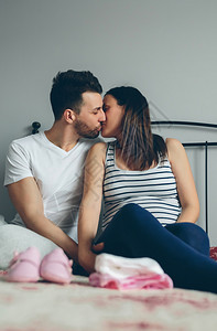年轻男子在卧室中亲吻其怀孕妻子男人亲吻其怀孕妻子图片