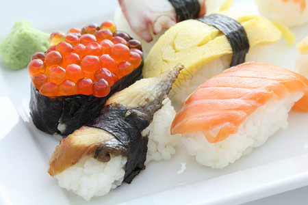 近视图盘子上各类美味可口的寿司图片