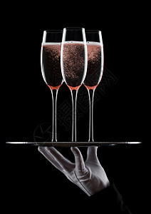 装着粉红玫瑰香槟杯黑色底有泡图片