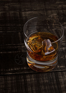 玻璃威士忌和木制桌背景顶视图上的冰块图片