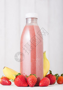 在草莓中屹立的粉色瓶子图片