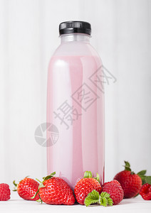 在草莓中屹立的粉色瓶子图片