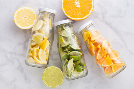 夏季新鲜水瓶橙子加柠檬和片大理石底新鲜水果图片