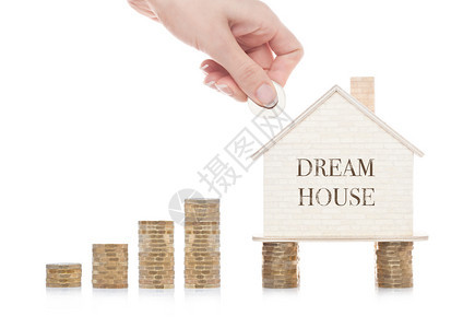 站在硬币上用概念文字手握硬币的木制房屋模型图片