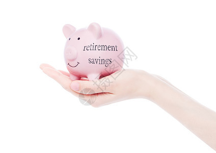 女手持带有退休储蓄概念案文的猪银行图片