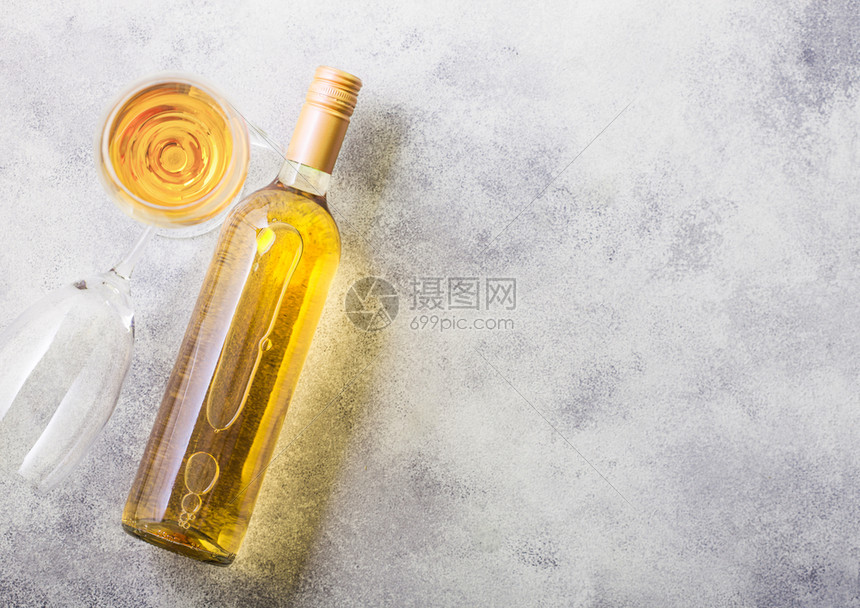 和白葡萄酒或石头厨房桌背景的瓶子杯顶部视图图片