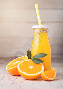 玻璃瓶有机新鲜橙汁浅木底带生橙子图片