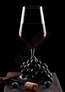 玻璃红酒黑葡萄色木板上图片
