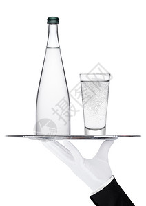 白色背景上装着瓶和玻璃杯静水的托盘图片