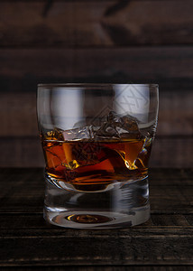 玻璃威士忌和木制桌底的冰块图片