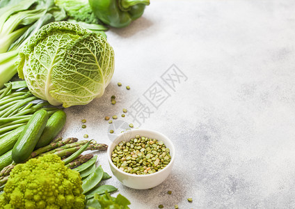 白种背景的绿色菜类青卷心椰和黄瓜配有三角豆和白碗碎图片