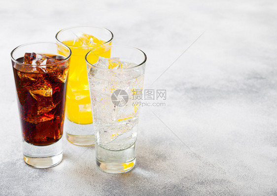 一杯苏打饮料与冰块和泡沫在石头厨房背景图片