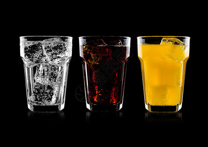 一杯可口乐橙苏打饮料和柠檬水用冰块在黑色底的面闪光水和冰块图片