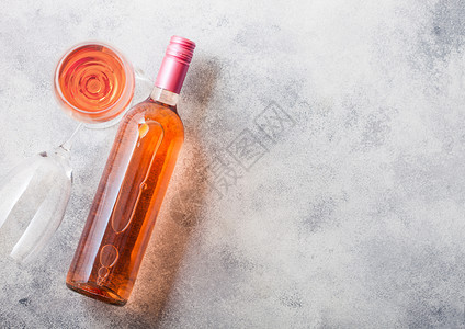 和粉红玫瑰酒的瓶子放在石头厨房餐桌背景上顶层风图片