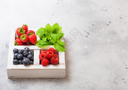 餐桌背景的白色圆边木箱中的新鲜有机果文本空间草莓蓝和薄荷叶图片
