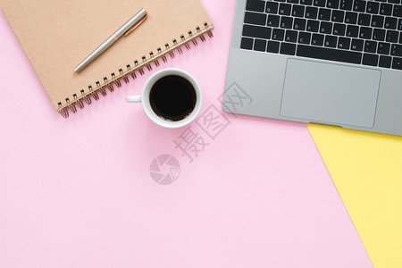 工作空间办公桌的顶端查看台有笔记本电脑空白的笔记本和咖啡杯彩色背景顶端视图有复制空间平面摄影图片