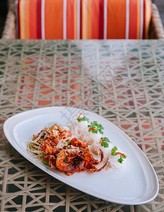 沙拉加深炸软壳螃蟹和面条在桌上的白盘面图片