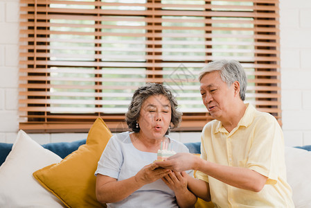 持蛋糕庆祝妻子和在家里客厅过生日图片