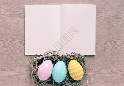 木底上带涂鸦的鸡蛋和空白笔记本图片