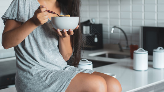 女子在厨房里吃麦片图片