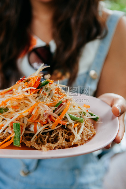 女人拿着泰河街食物烹饪菜盘沙拉加辣番茄沙拉和炸鱼蛋糕图片