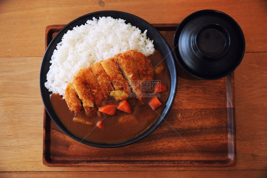 咖喱米饭用木制桌上的日本食煎猪肉图片