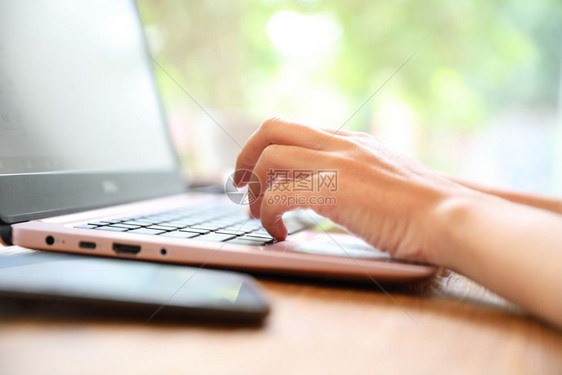 妇女手在咖啡店工作手在键盘上贴近图片