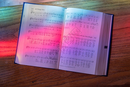 彩色玻璃窗的光线落在美国教堂的公开歌曲簿上图片