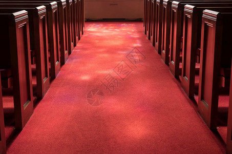 红地毯教堂过道之间有红地毯的教堂过道在上有彩色玻璃窗的灯光照亮有彩色玻璃窗的光线图片