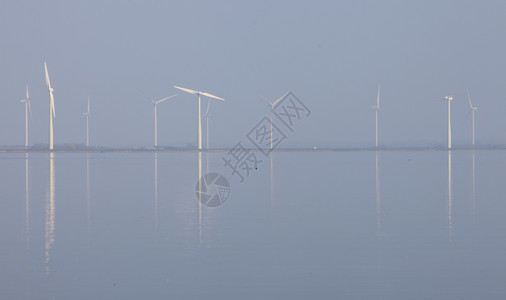 反映于内地Huizen附近Emr水中的风涡轮机和蓝天空图片