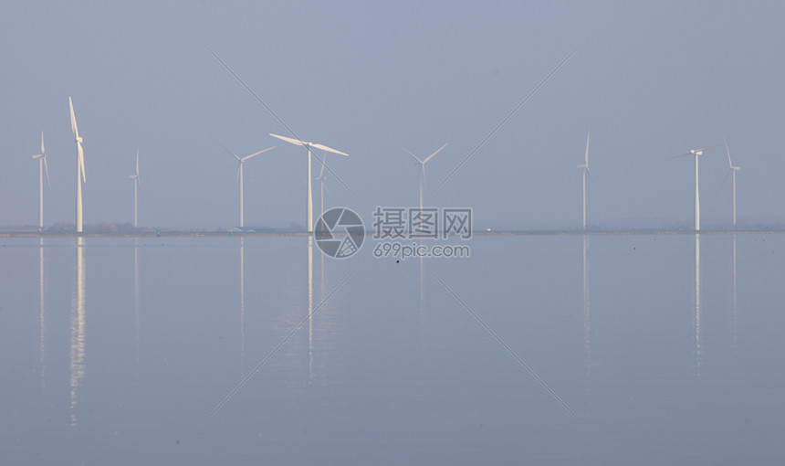 反映于内地Huizen附近Emr水中的风涡轮机和蓝天空图片