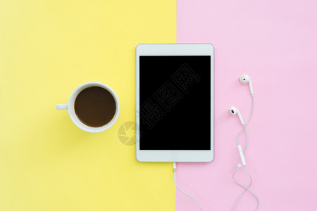 夏季旅行的平板设计概念粉红色黄面纸彩屏幕上空白的平板电脑和咖啡杯的顶部视图上面有复制空间夏季旅行时有糊面彩色背景图片