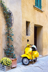 骑摩托车站在意大利老城的空街上图片