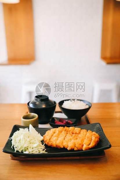 Tonkatsu炒猪肉切菜加大米和木桌上的日本菜汤图片