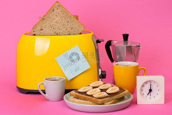 亮的有趣早餐粉红背景的黄面包机图片