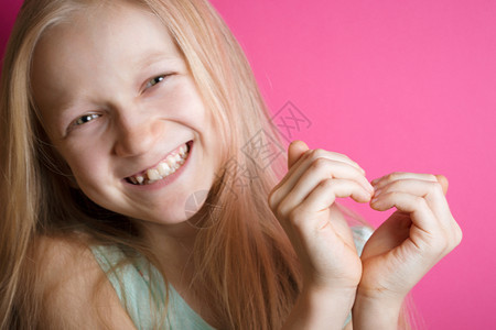 笑着的女孩双手折叠在心脏的形状图片