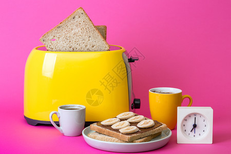 黄面包机和一杯粉红背景的咖啡背景图片