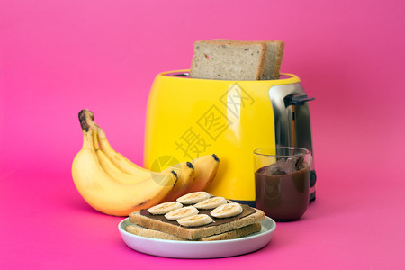 黄面包机和一杯粉红背景的咖啡背景图片