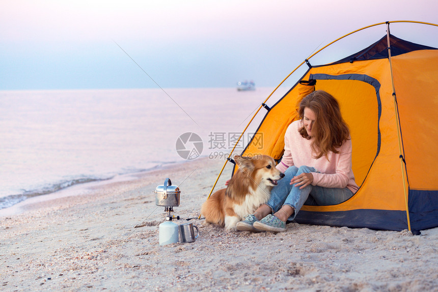 早晨在海滩的帐篷里带着一条狗的女孩在阿佐夫海边的乌拉尼风景图片