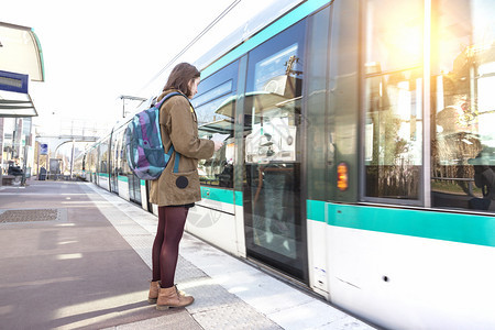 乘坐背包在平台上站着的女游客等待在巴黎的火车图片