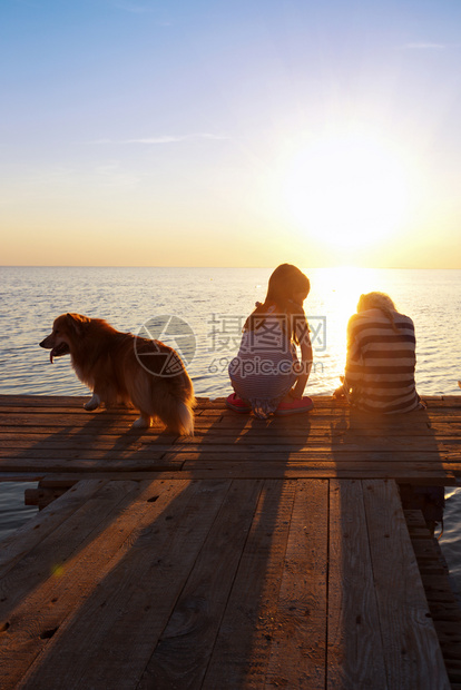 日落时在码头有两个小女孩乌拉尼海面的风景图片