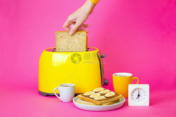 女孩准备烤面包黄机和粉红背景的咖啡图片