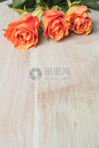 木制桌上一束橙色玫瑰复制空间图片