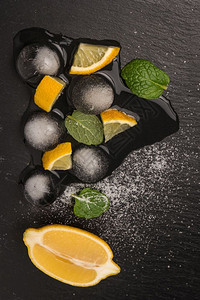 切片和半新鲜的多汁柠檬加上薄荷叶和板的冰融化图片