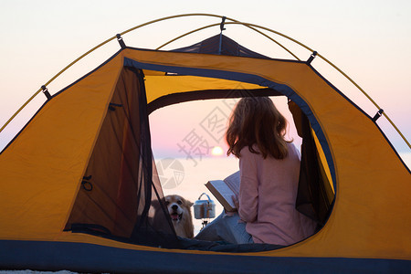 早晨在海滩的帐篷里带着一条狗的女孩在阿佐夫海边的乌拉尼风景图片