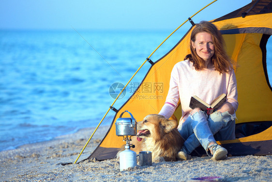 早晨在海滩的帐篷里带着一条狗的女孩在阿佐夫海边的乌拉尼风景图片