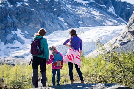 母亲和女儿们在山上远足看着冰川图片