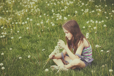 年轻金发女孩在绿草坪上挂着一帮花公子图片