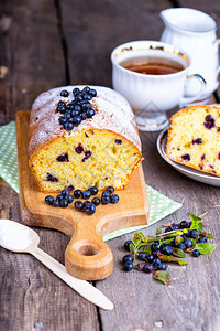 蓝莓蛋糕和木制桌上的茶图片