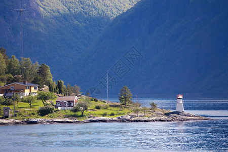 海湾岸上的灯塔和多彩房屋图片